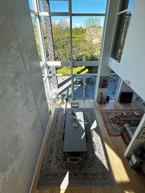 Un interior moderno con comedor, chimenea y ventanas amplias que dan a un jardín.