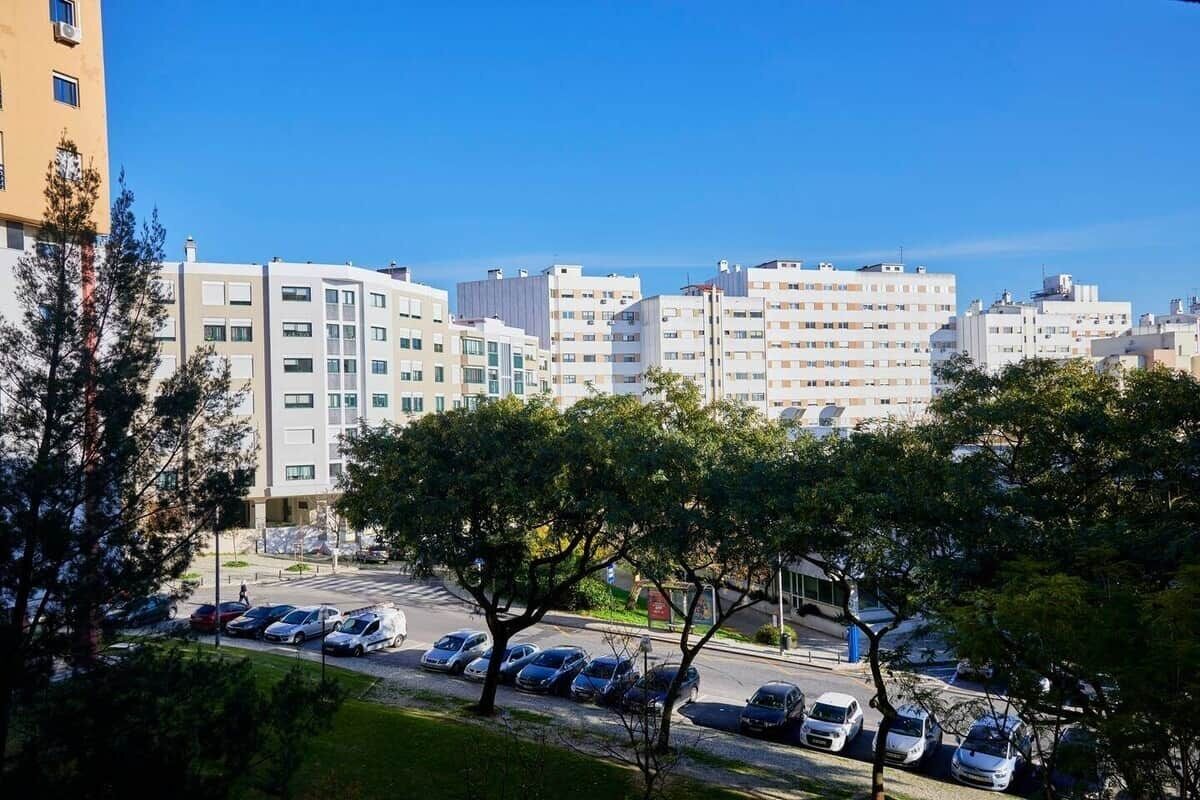 Un edificio residenziale a più piani con un parcheggio di fronte.