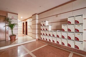 Eine Hotelhalle mit Blumentopf, einer Rezeption und einer Reihe von Briefkästen.