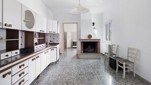 A modern kitchen with white cabinets, a black countertop, and a tiled floor.