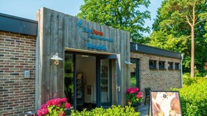 Een houten gebouw met een bordje voor 'EuroParc Resort Rechterthal' en een receptie.