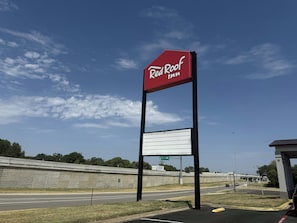 A Red Roof Inn sign with a blank billboard below it, set against a clear sky with a highway in the background. - Red Roof Inn Sherman (Sherman)