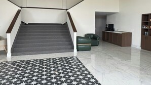 Un interior modern amb una escala que condueix a un nivell superior, una zona de cuina i una catifa amb disseny.