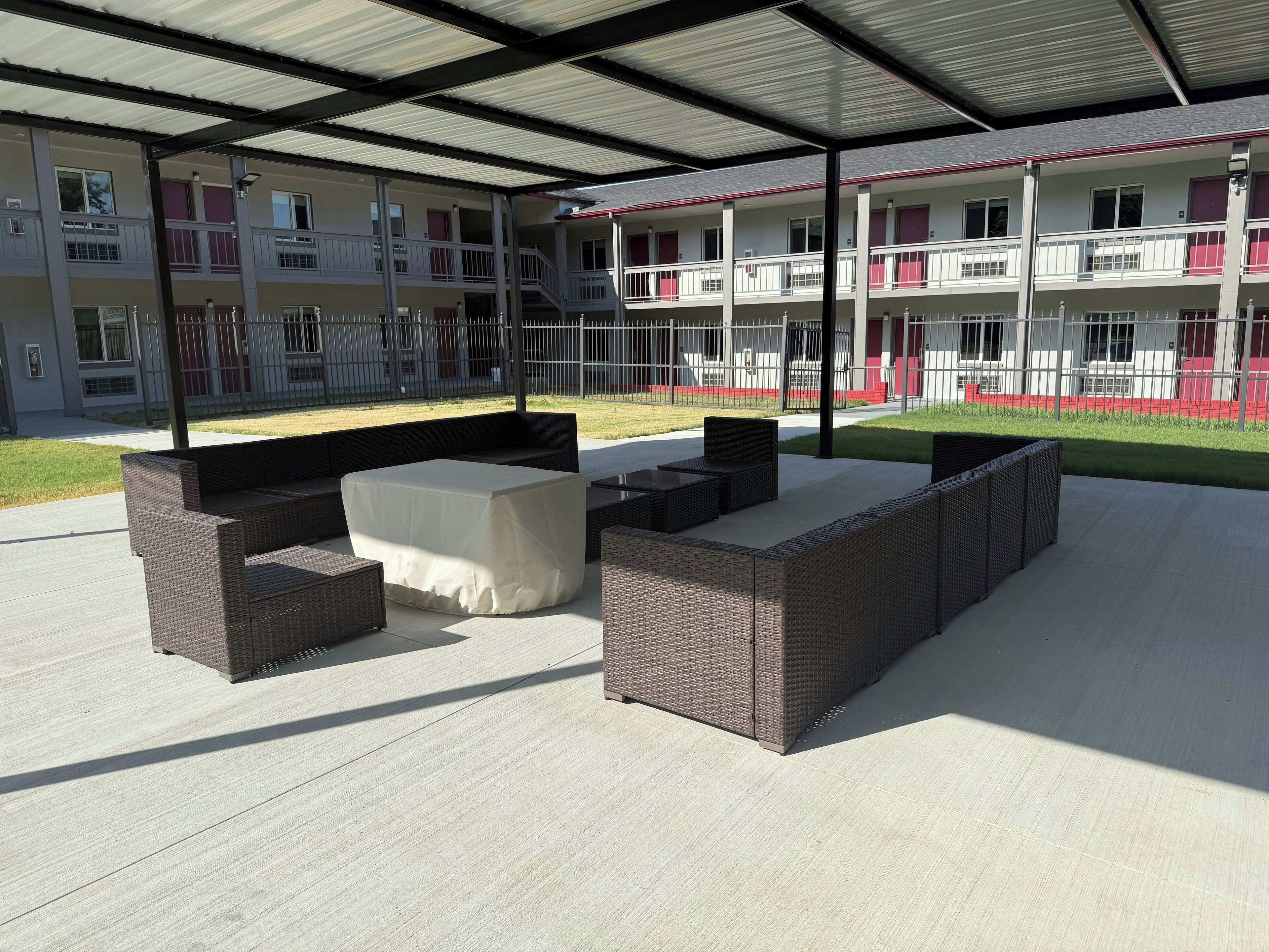 An outdoor patio area with wicker furniture and a covered section.