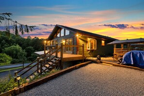 Ein modernes Haus mit Terrasse, einer Treppe und einem Grillbereich.