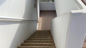 A staircase with white walls and tiled flooring leading to an upper level. - Ca Festa Residence: Two-room apartment Ca Festa 51 for 6 people (Chioggia)