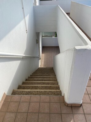 A staircase with white walls and tiled flooring leading to an upper level. - Ca Festa Residence: Two-room apartment Ca Festa 51 for 6 people (Chioggia)