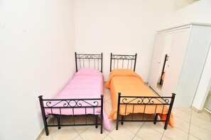 Two metal beds with different colored bedding in a room with a white wardrobe. - Residenz Arcobaleno, Stella Marina 2 Two-Room Apartment for 4 People (Chioggia)