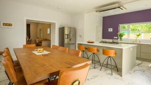 A modern kitchen with a large island, bar stools, and a dining table with chairs. - The Stone House Sleeps 10 With Parking (Clarinbridge)
