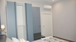 Ein Hotelzimmer mit Bett, einem Badezimmer mit Dusche und einer Klimaanlage.