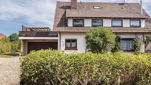 A two-story house with a tiled roof, a garage, and a well-maintained garden.