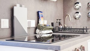 A modern kitchen with a built-in stove, a sink with a faucet, and a towel rack.
