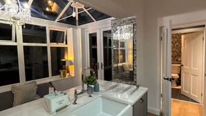 Une cuisine moderne dotée d’un grand îlot central, d’un éclairage suspendu et offrant une vue à travers la lucarne.