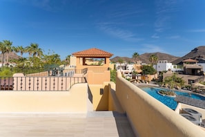 Ein Resort mit Schwimmbad, einer überdachten Terrasse und Blick auf die umliegende Landschaft.