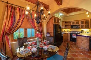 A kitchen with wooden cabinets, a black refrigerator, and a tiled backsplash. - Cozy Home a few Steps From Community Pool (  Loreto)