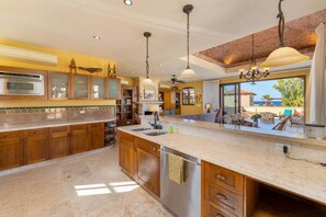 A spacious kitchen with a large island, wooden cabinets, and a view of the sea. - Beautiful Custom Home. Amazing Ocean View (  Loreto)