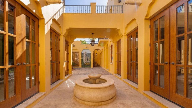 A corridor with wooden doors and a central fountain. - Beautiful Custom Home. Amazing Ocean View (  Loreto)