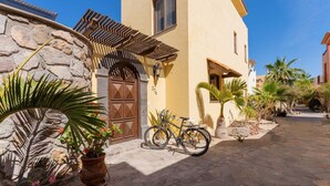 A stone building with a wooden door, a bicycle, and potted plants. - Home With Stunning Ocean View and Breathtaking Sights of the Sierra La Giganta (  Loreto)