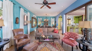 A spacious living room with a ceiling fan, a dining area with a chandelier, and a kitchen with green cabinets. - Home With Stunning Ocean View and Breathtaking Sights of the Sierra La Giganta (  Loreto)