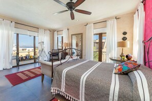 Ein Schlafzimmer mit Bett, Deckenventilator, Balkon und Blick.