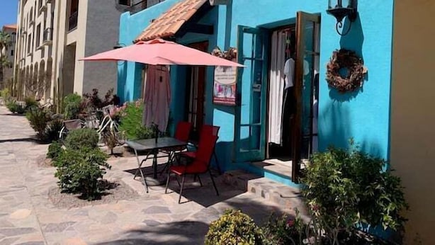 A building with a blue facade, a wooden balcony, and a table with chairs outside. - Oceanview Escape With Rooftop Terrace & Mountain Views Welcome to Your Perfect Coastal Retreat! (FN397 Loreto)