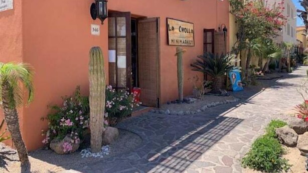 Un edificio con un letrero que dice "La Cholla Mini Market" y el número "346" sobre la puerta.