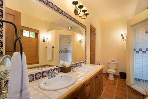 Une salle de bain avec deux lavabos, un grand miroir et un espace douche.