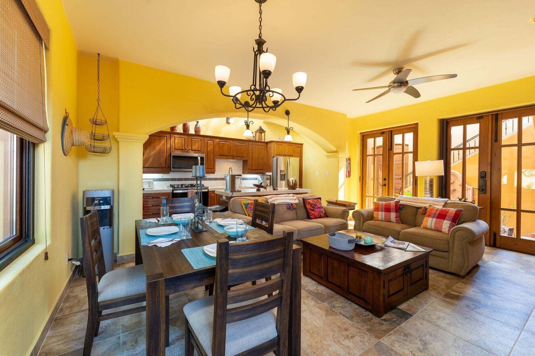 Amplia sala de estar con comedor y cocina al fondo, además de un ventilador de techo.