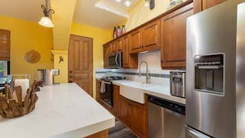A modern kitchen with wooden cabinets, stainless steel appliances, and a white countertop.