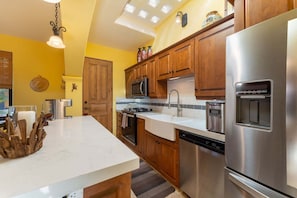 A modern kitchen with wooden cabinets, stainless steel appliances, and a white countertop. - Wonderful Home Next to the Community Pool (  Loreto)