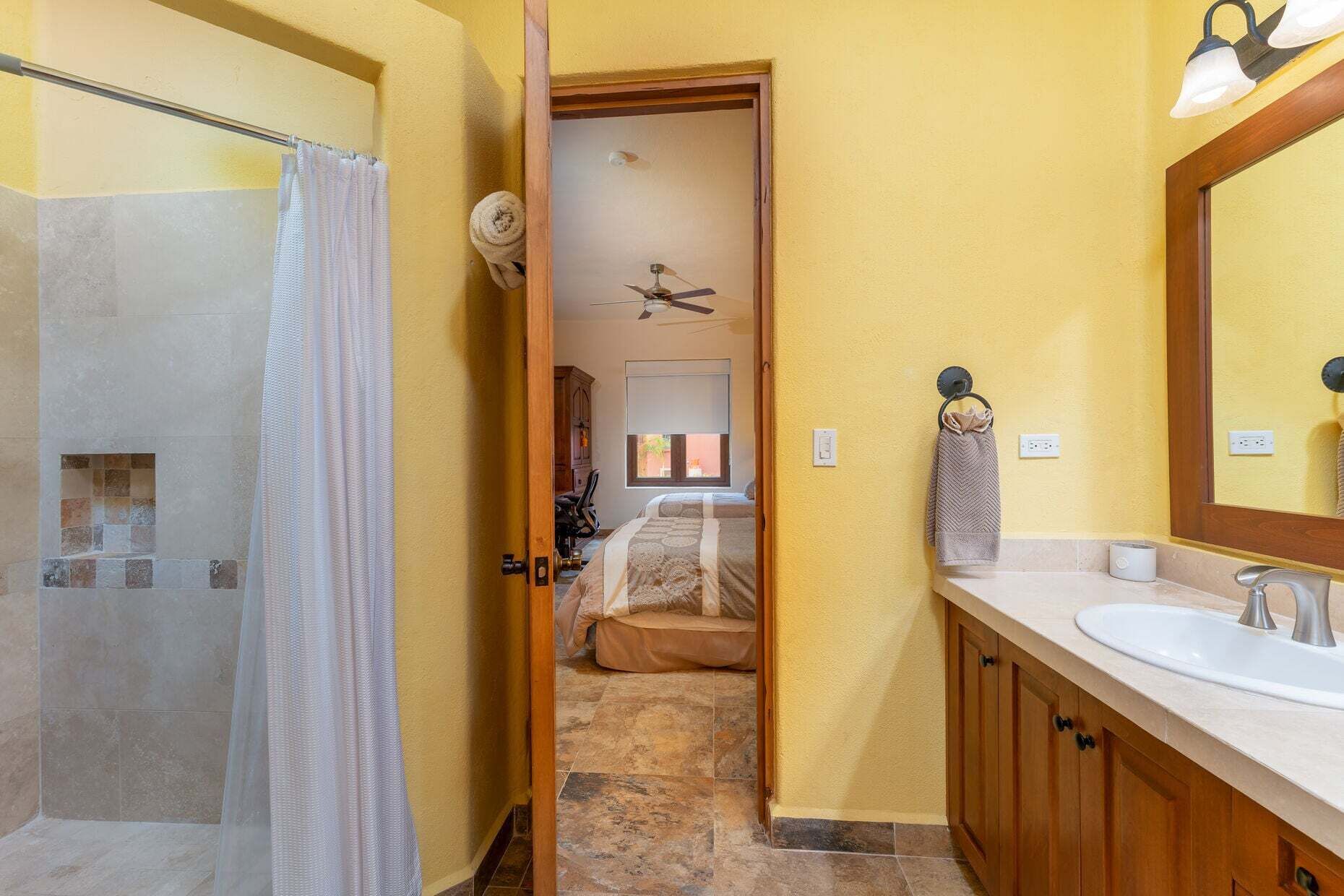 A bathroom with a shower, a sink, and a mirror.