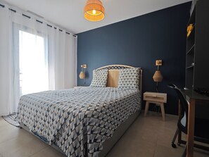 Ein Schlafzimmer mit einem Bett, einem Schreibtisch und einem Stuhl.