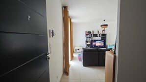 Käytävän päässä on keittiö, jonka ovessa on tumma väri, siellä on myös valokatkaisin ja pieni kaappi.