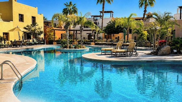 A pool area with lounge chairs and palm trees. - Our Exquisite Casa Offers a Perfect Blend of Comfort and Convenience ( Avenida punta sal Loreto)