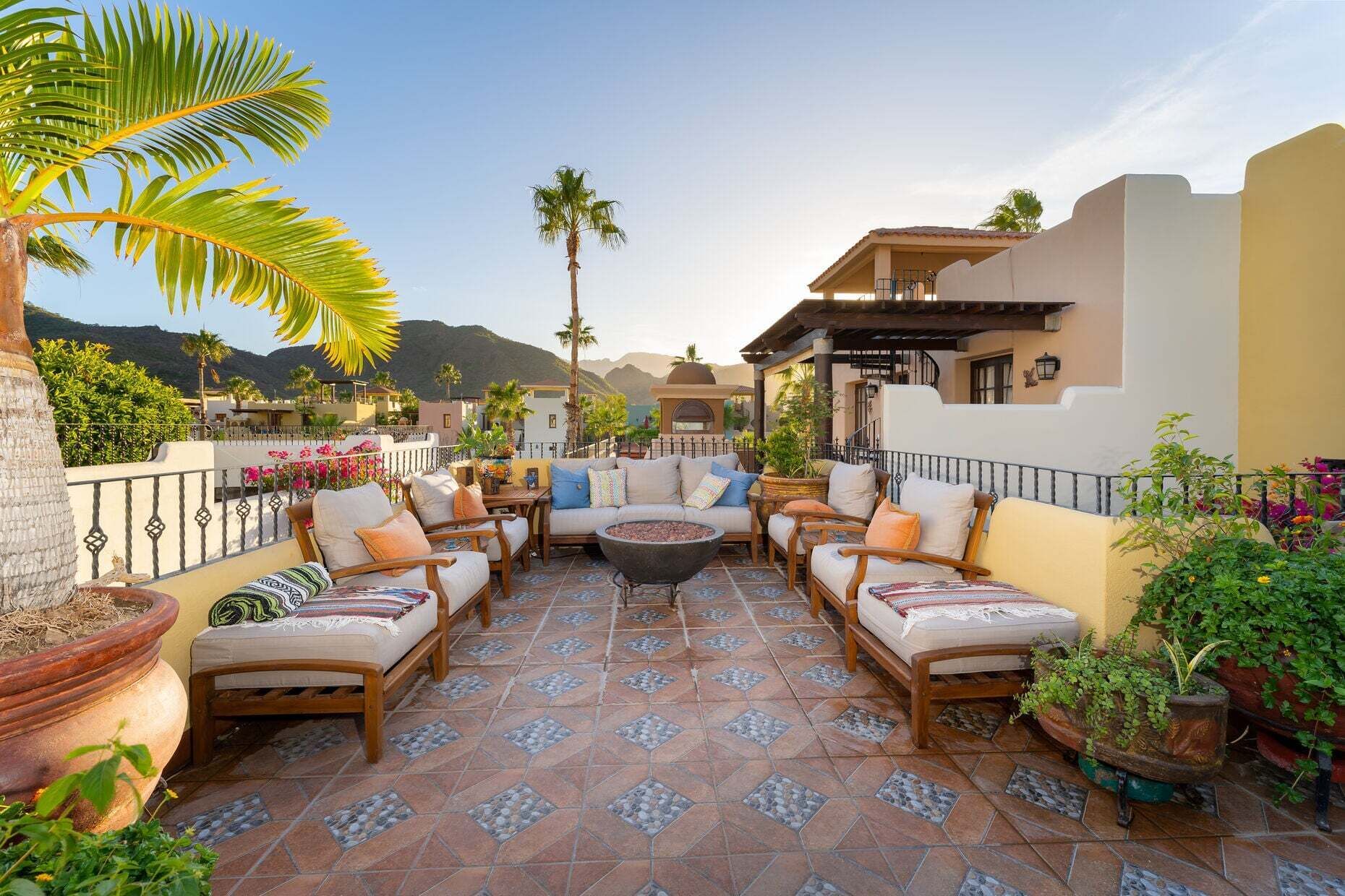 Eine Terrasse mit Gartenmöbeln, Blumentöpfen und Blick auf die Umgebung.