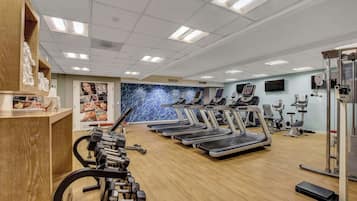 A gym with treadmills, elliptical machines, and weightlifting equipment.