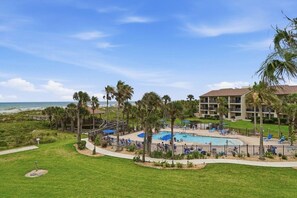 A resort with a pool, palm trees, and a view of the ocean. - Seaside Escape- Holiday by the sea + private beach (St. Augustine Beach)