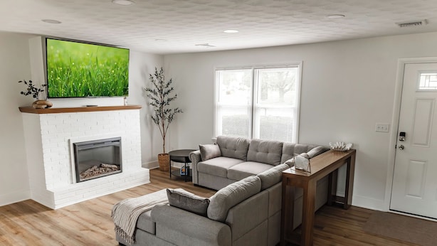 Una sala de estar con chimenea, televisor, sofá y mesa de centro.