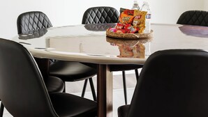 Ein Konferenzraum mit rundem Tisch, schwarzen Stühlen, einer Weltkarte an der Wand und Snacks auf dem Tisch.