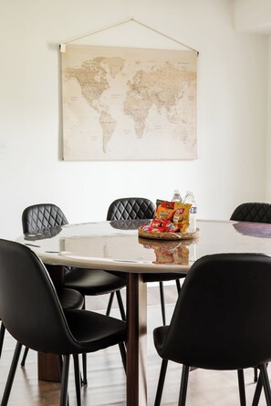 A conference room with a round table, black chairs, a world map on the wall, and snacks on the table.