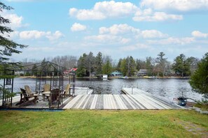 A wooden dock extending into a lake with a gazebo and chairs, surrounded by houses and trees. - Lake Muskoka Escape - McVittie Island|Wifi|Firepit (Bracebridge)