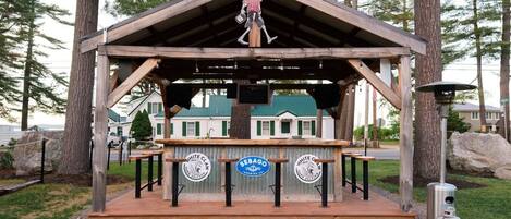 A wooden structure with a metal roof, a signboard, and two gas cylinders.