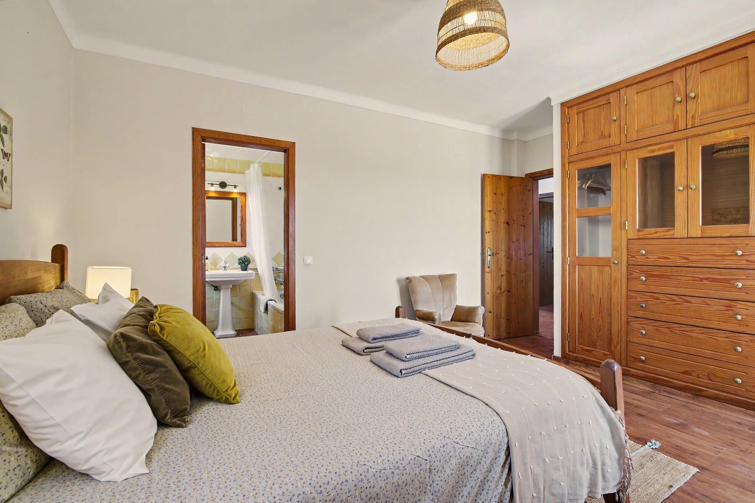 Une chambre à coucher avec un lit, une armoire en bois et un miroir.