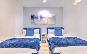 Ein Hotelzimmer mit zwei Betten, einem kleinen Tisch und Bildern an der Wand.