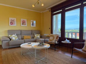 A living room with a sofa, two side tables, a coffee table, and artwork on the wall. - House with Pool and BBQ _ Near the Beach by Easyliferent (Veiga da Vila)