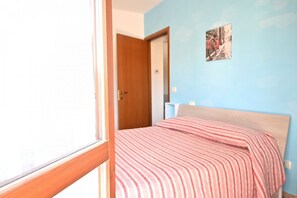 A bedroom with a bed, a door, and a wall with a picture. - SE272 - Senigallia, new fully equipped one-bedroom apartment with private garage (Senigallia)
