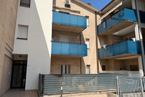 Edificio residenziale a più piani con balconi, ingresso chiuso da cancello e una porta con il numero 50 ben visibile.