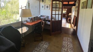A room with a desk, chair, lamp, and a view of the outdoors.