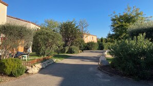 Eine Wohnstraße mit Häusern, Bäumen und blauem Himmel.