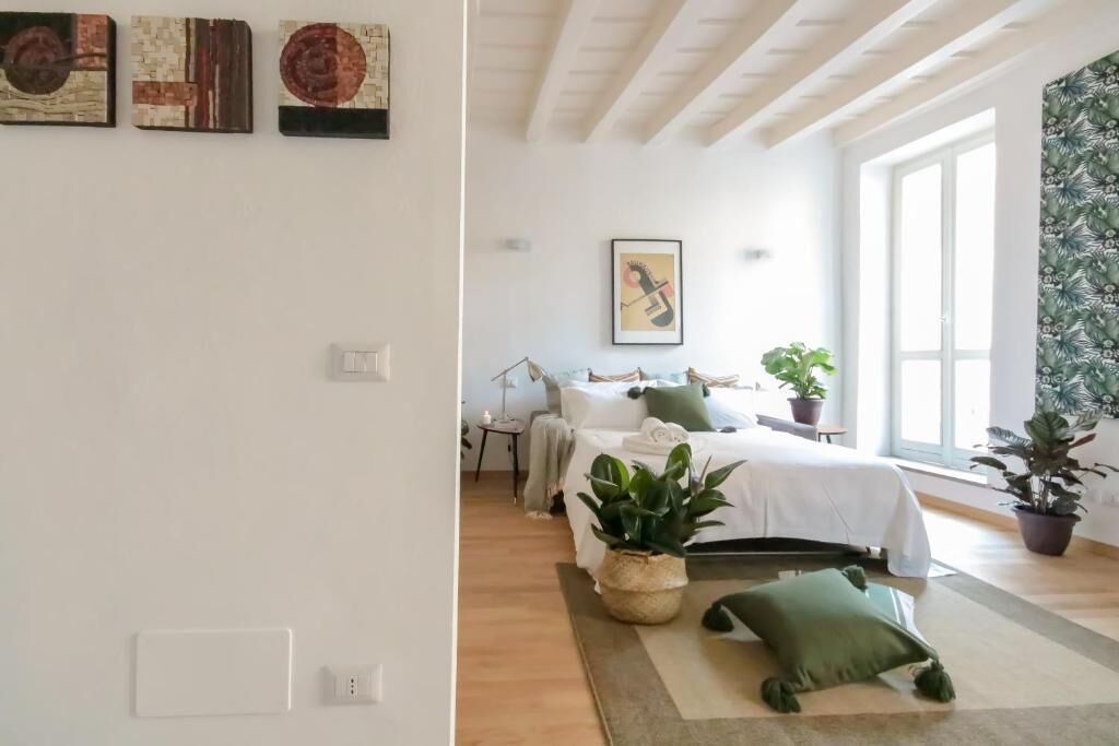 Una camera da letto con un letto, comodini, un tavolino e una pianta in vaso.